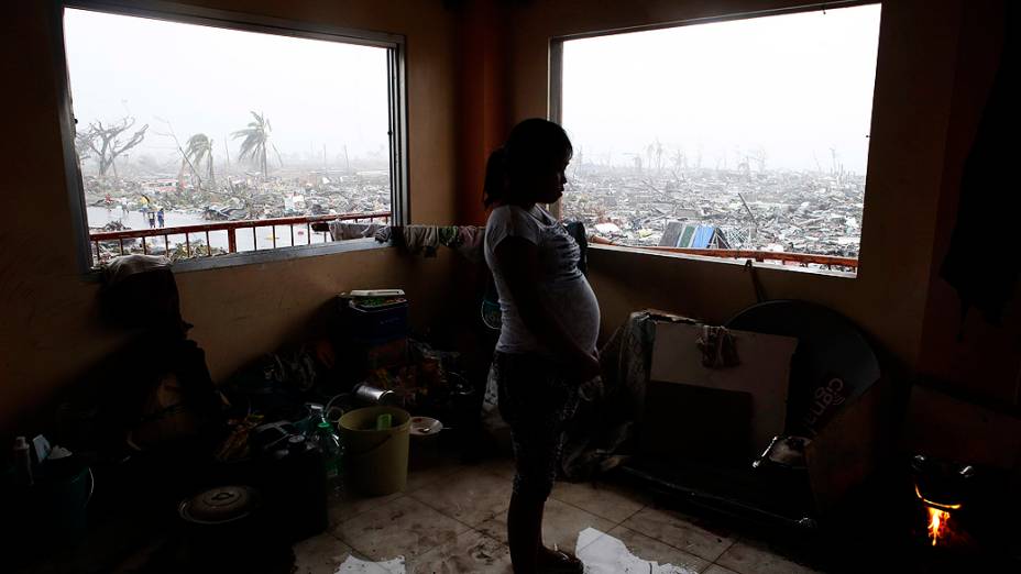 Grávida prepara refeição em um prédio que manteve-se de pé após passagem do supertufão Haiyan na cidade de Tacloban, região central das Filipinas
