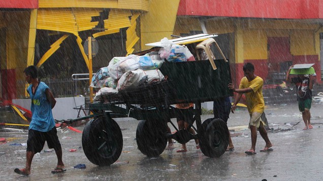 Moradores usam carroças para carregar seus pertences na cidade de Tacloban, região central das Filipinas