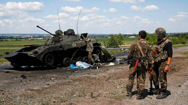 Soldados ucranianos inspecionam um tanque destruído usado por rebeldes pro-Rússia, em Slaviansk na Ucrânia