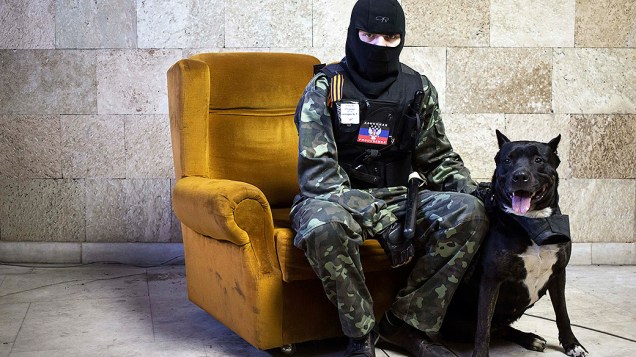 Militante pró-Rússia mascarado posa para foto dentro de prédio do governo regional invadido em Donetsk, leste da Ucrânia