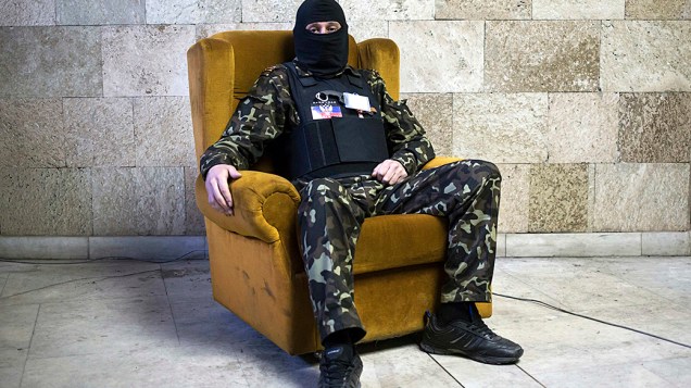 Militante pró-Rússia mascarado posa para uma foto dentro de um prédio do governo regional em Donetsk, leste da Ucrânia