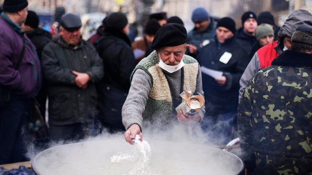 Homem prepara refeição para os manifestantes que se estabeleceram na Praça da Independência, em Kiev em protesto à decisão do presidente ucraniano, Viktor Yanukovych, de suspender um acordo comercial com a União Europeia