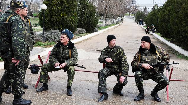 Pilotos da força aérea ucraniana montam guarda na base aérea militar em Belbek, perto de Sebastopol, que está cercada por forças russas