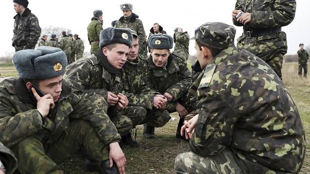 Soldados ucranianos descansam perto da entrada da base aérea de Belbek na periferia de Sebastopol, na Crimeia