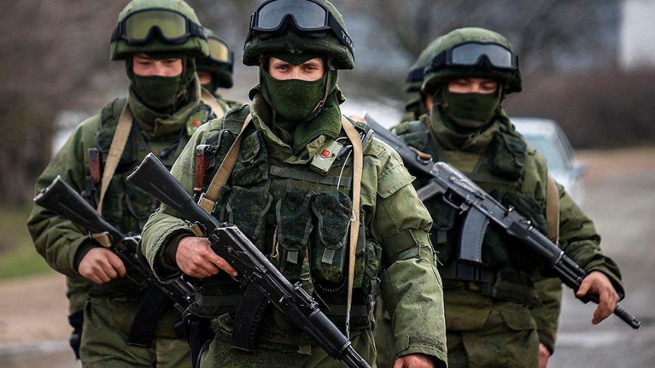 Homens armados, supostamente militares russos, marcham fora de uma base militar ucraniana na aldeia de Perevalnoye perto da cidade de Simferopol, na região da Crimeia