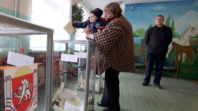 Criança segura o voto do referendo que decidirá se a Crimeia deve ou não se separar da Ucrânia