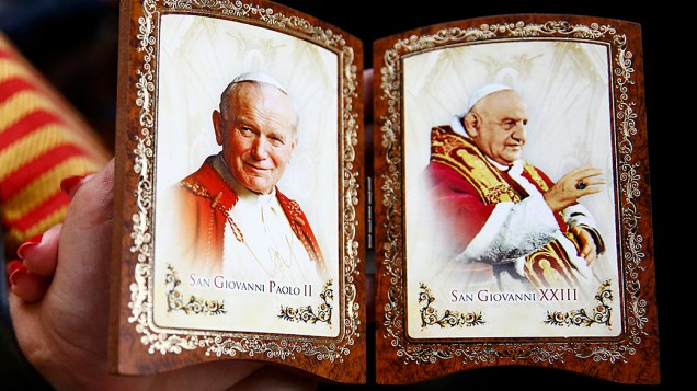 Fiel segura souvenir com as imagens dos papas João XXIII e João Paulo II, canonizados neste domingo (27)
