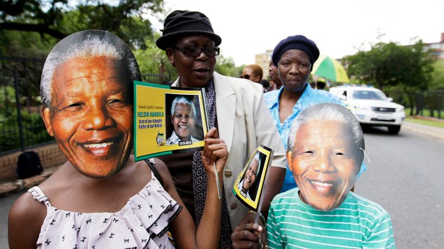 Crianças usam máscaras do ex-presidente sul-africano Nelson Mandela em uma fila para ver seu caixão, na capital Pretória, África do Sul