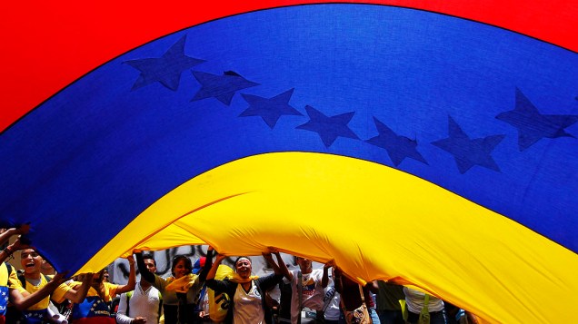 Partidários da oposição seguram uma grande bandeira nacional durante protesto em Caracas, em 21/03/2013