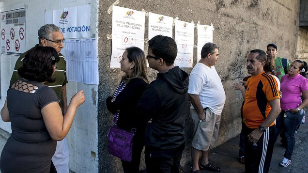Eleitores aguardam na de entrada de um centro de votação durante as eleições municipais, em Caracas