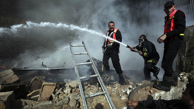 Bombeiros palestinos apagam incêndio causado por ataque aéreo, em Jabaliya, norte da Faixa de Gaza