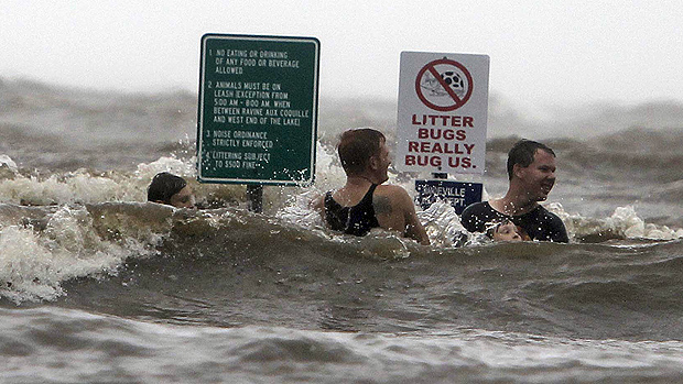 Jovens nadam em uma rua inundada ao lado do lago Pontchartrain, em Mandeville, na Louisiana (EUA), após a passagem do furacão Isaac pelo Estado