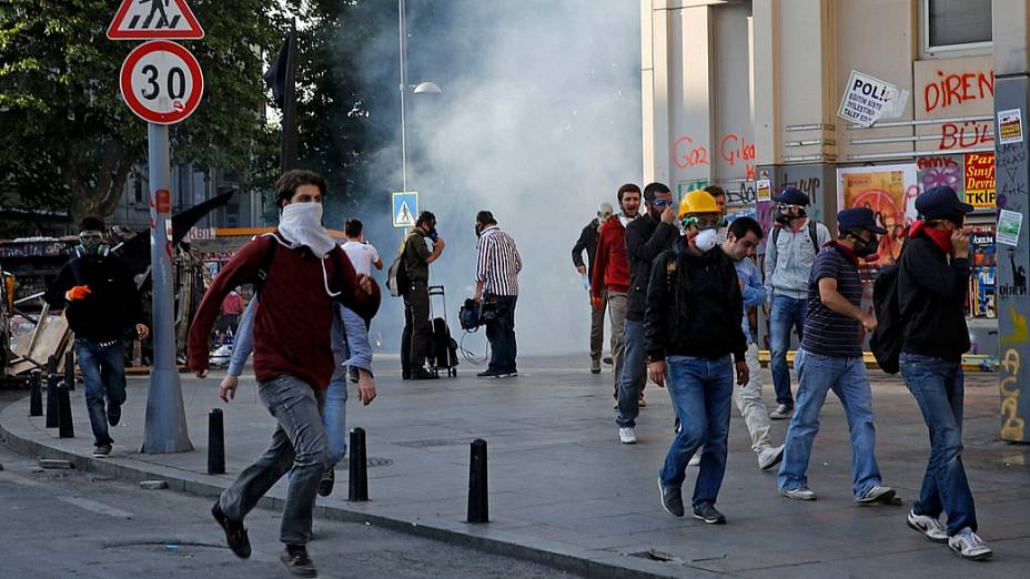 Manifestantes correm de blindados da polícia, que usa jatos dágua e gás lacrimogêneo para desocupar praça