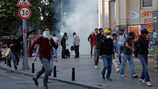 Manifestantes correm de blindados da polícia, que usa jatos dágua e gás lacrimogêneo para desocupar praça