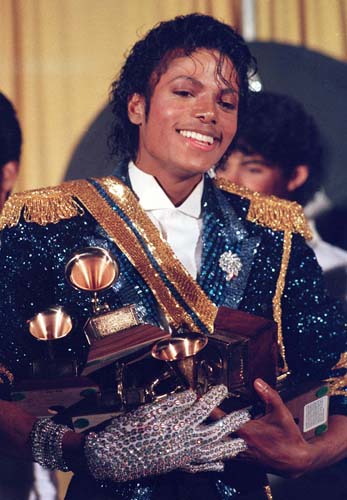 Carregando prêmios de diversas categorias, o astro deixa o Grammy de 1984 com uma jaqueta brilhante azul