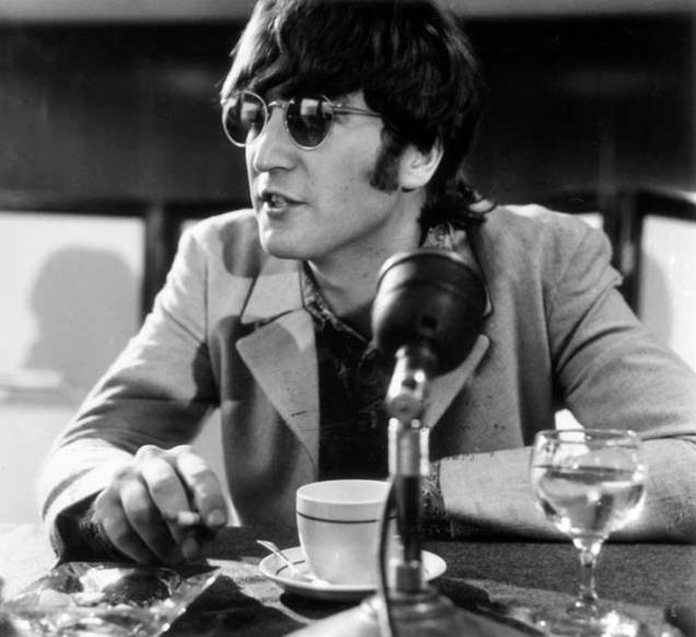 John Lennon participa de coletiva de imprensa com os Beatles no Aeroporto de Londres após retornarem de Manila em julho de 1966
