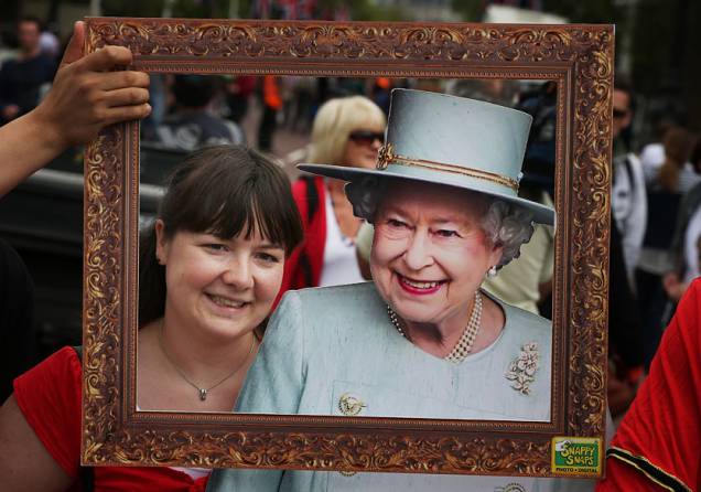 Mulher fotografada com banner da rainha Elizabeth II em The Mall próximo ao Palácio de Buckingham em Londres, Inglaterra. Dois dias antes do início das celebrações do Jubileu de Diamante