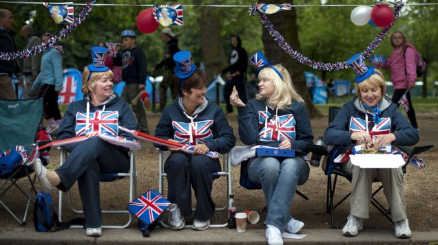 Mulheres aguardam show na parte externa do Palácio de Buckingham, em Londres