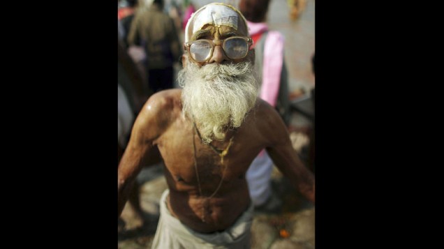 Peregrino de 90 anos posa para retrato após banho sagrado no Rio Sagram, na índia