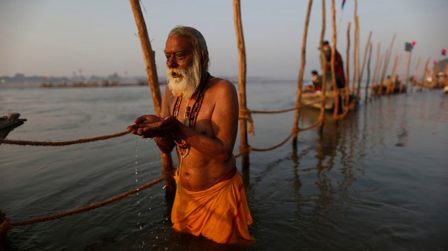 Devoto hindu reza antes do mergulho nas águas sagradas do Rio Ganges