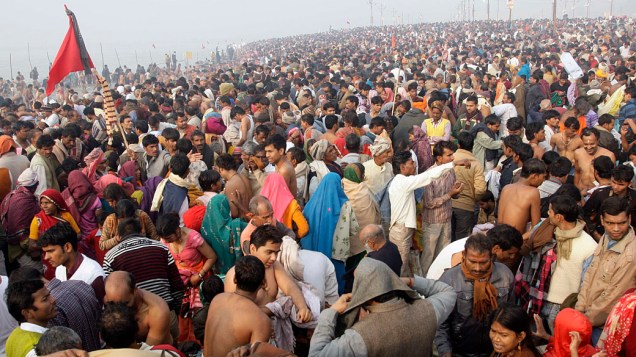 Devotos hindus se vestem após banho no Rio Ganges durante o Kumbh Mela, maior festival religioso do mundo que acontece na Índia