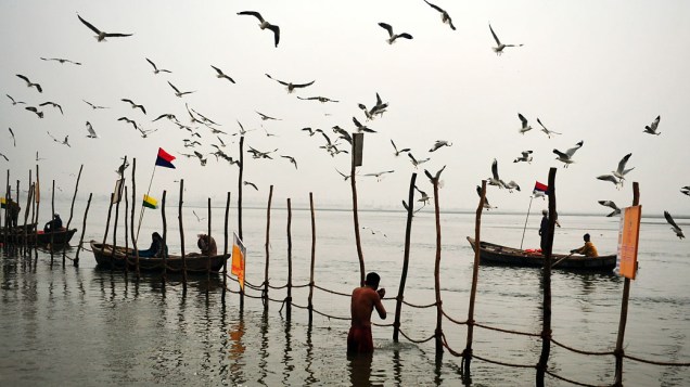 Devotos hindus se banham nas águas do Ganges durante o dia Makar Sankranti, no início do Kumbh Mela Maha em Allahabad, Índia