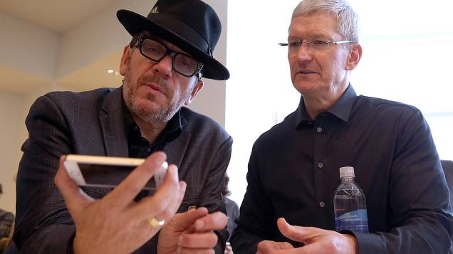 O cantor Elvis Costello segura o novo iPhone 5S ao lado do CEO da Apple Tim Cook após evento de lançamento, em Cupertino na Califórnia