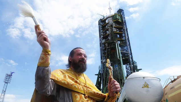 Um padre da igreja ortodoxa russa abençoa o foguete Soyuz TMA-04M, que decolou com três astronautas