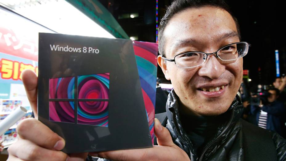 Usuário posa para foto após adquirir o Windows 8 em uma loja de Akihabara, Tóquio