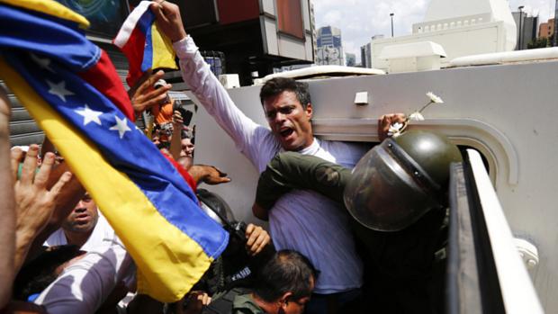 O opositor Leopoldo López é colocado dentro de veículo da Guarda Nacional depois de se entregar à polícia em Caracas, na Venezuela