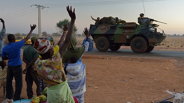 Malineses acenam para comboio de tropas francesas