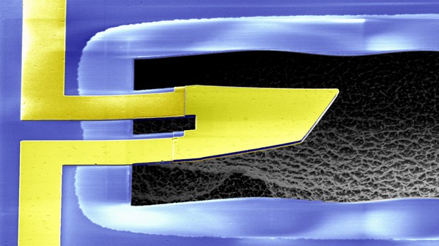 O objeto central amarelo é a 'microplaca', suspensa no ar por dois apoios e com a espessura de um fio de cabelo