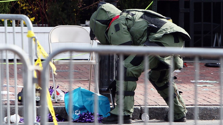 Membro do esquadrão antibombas procura por intens suspeitos, após a explosão na maratona de Boston