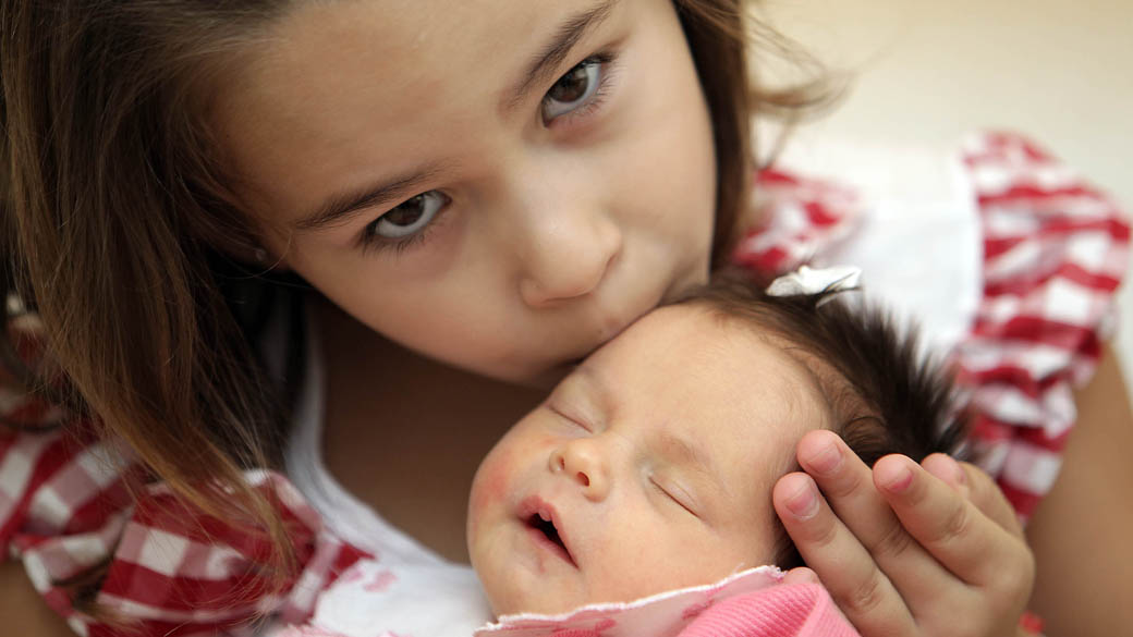 As irmãs Maria Vitória e Maria Clara Reginato Cunha apenas quatro dias após o nascimento da caçula, em 2012