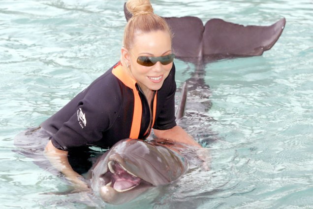 Em 2003, junto com um golfinho no parque aquático Discovery Cove, em Orlando.