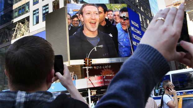 Mark Zuckerberg, fundador do Facebook, aparece em telão em Nova York e pedestres registram momento tirando fotografias na Times Square