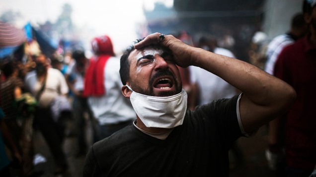   Homem se desespera durante protesto que terminou em confronto entre manifestantes que apoiam o presidente deposto do país, Mohamed Mursi, e a polícia, no Cairo, nesta quarta-feira (14)