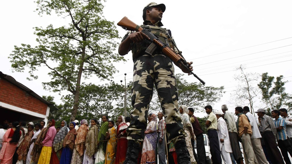 Membro das forças de segurança indianas faz a segurança de um colégio eleitoral no estado de Assam, na Índia