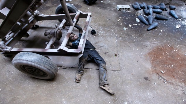 O jovem Issa, 10 anos, ajuda seu pai em uma fábrica que fornece armamentos para o Exército Livre da Síria, em Alepo