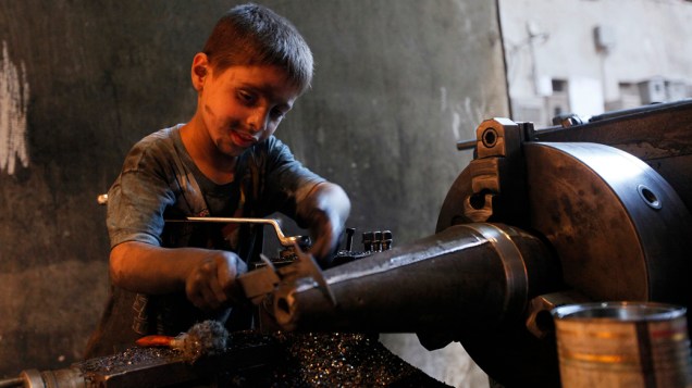 O jovem Issa, 10 anos, ajuda seu pai na fábrica que fornece armamentos para o Exército Livre da Síria, em Alepo