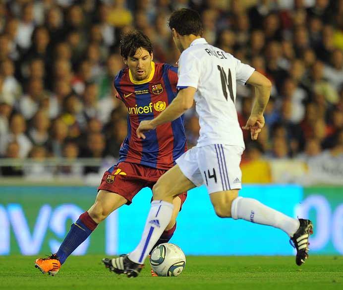 Messi em lance com Xabi Alonso durante a partida entre Real Madrid e Barcelona pela final da Copa do Rei, Valência
