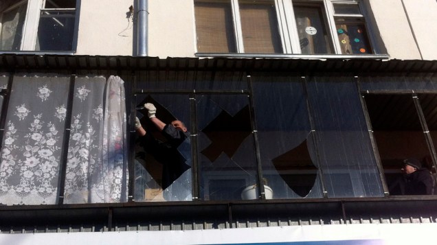 <p>Homem conserta janela danificada pela queda de meteorito na Rússia</p>
