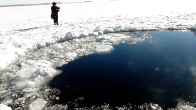 <p>Buraco aberto no gelo pela queda do meteorito na cidade de Chelyabinsk Urais, na Rússia</p>