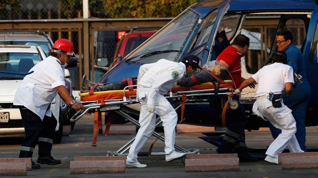 Paramédicos levam ferido pela explosão na Pemex até helicópetero