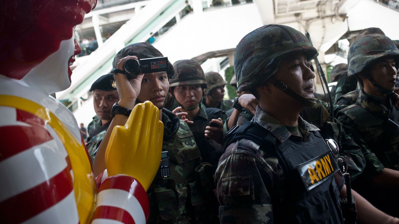 Militares tailandeses montam guarda em frente a um restaurante do McDonald's conhecido por ser um ponto de encontro de manifestantes opositores ao Exército