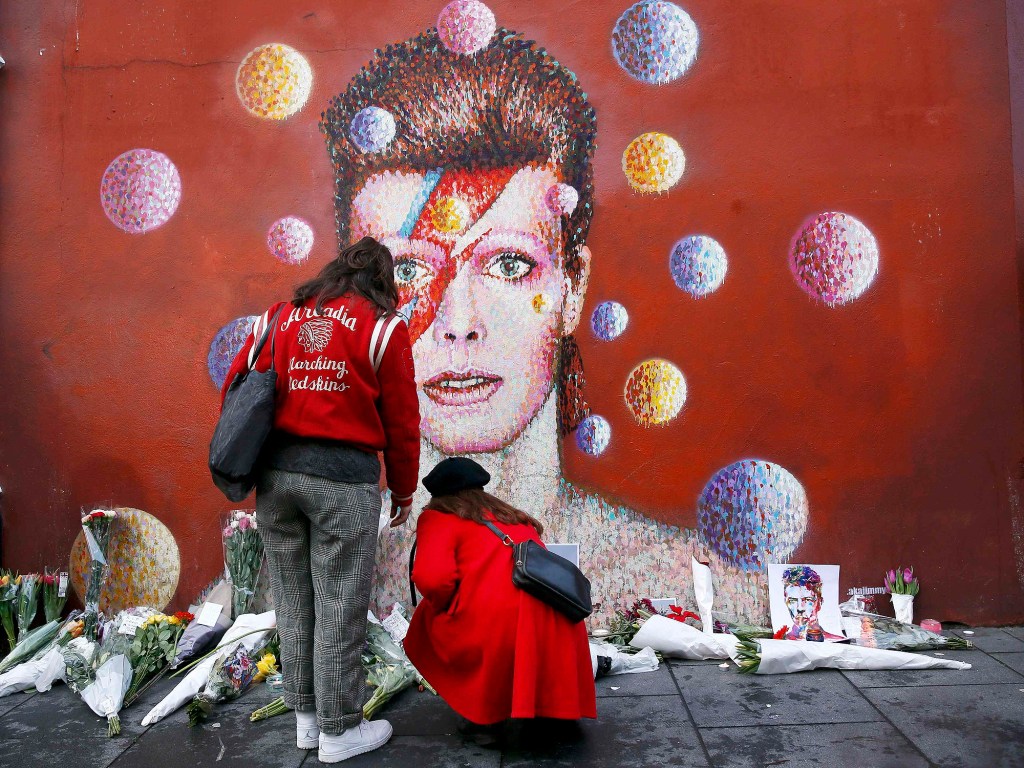 Ingleses deixam flores em frente a uma famosa pintura de David Bowie em Londres, nesta segunda-feira