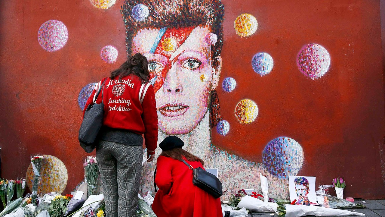 Ingleses deixam flores em frente a uma famosa pintura de David Bowie em Londres, nesta segunda-feira