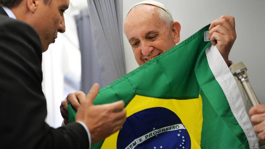 Papa Francisco recebe uma bandeira do Brasil a bordo do voo papal para o Rio de Janeiro, para participar da Jornada Mundial da Juventude