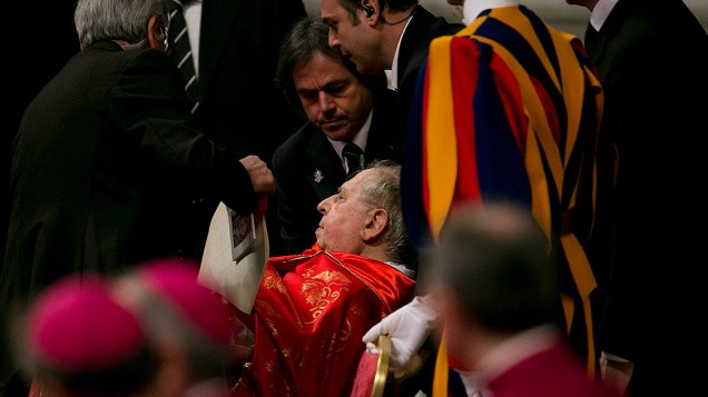 O cardeal italiano Antonio Maria Veglio recebe ajuda ao passar mal durante a missa Pro Eligendo Pontifice
