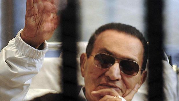 Hosni Mubarak acena a apoiadores em cela durante audiência em abril de 2013